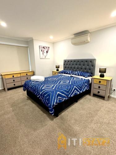 a bedroom with a bed and two night stands at Comfortable & Spacious -2bd 2bth - Braddon in Canberra