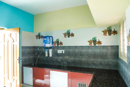 een keuken met een zwart aanrecht en blauwe muren bij Nandhi home stay in Tiruvannamalai