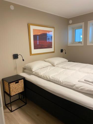 a large bed in a room with a night stand at Modern apartment with mountain and sea view in Svolvær