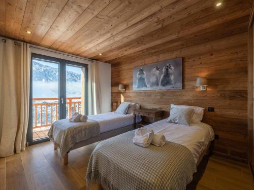 ein Schlafzimmer mit zwei Betten und einem großen Fenster in der Unterkunft Chalet moderne, 5 chambres, proche remontées, parking, Wi-Fi - FR-1-754-88 in Morzine
