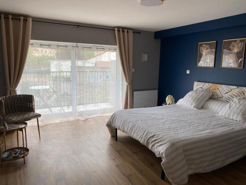 a bedroom with a bed with a blue wall at Chez Marie et Angel in Autun