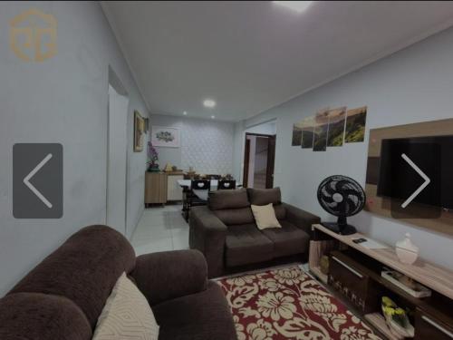 a living room with a couch and a tv at apto frente praia pé na areia 2dorm wifi elevador Smart tv praia grande aviação - leia fotos in Praia Grande