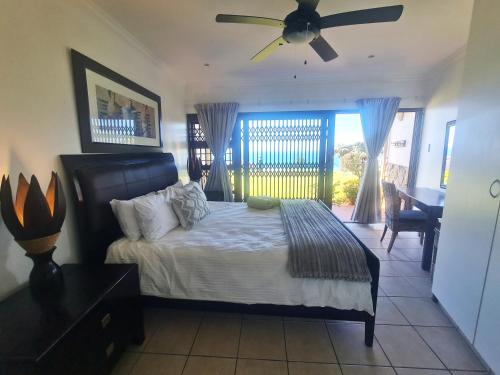 a bedroom with a bed and a ceiling fan at Kuta Beach 7 in Margate