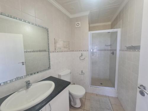 a bathroom with a sink and a toilet and a shower at Kuta Beach 7 in Margate