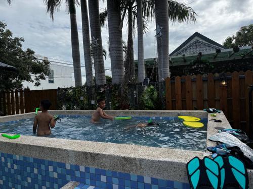 two boys playing in a swimming pool with frisbees at 寧靜の家B區12人Villa獨棟 in Hengchun