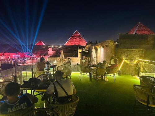 a group of people sitting in chairs at an event at Inside Pyramids Inn in Banī Ghālib