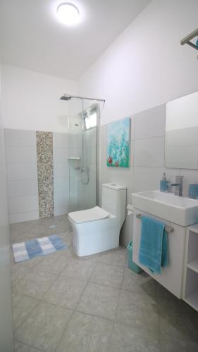 a white bathroom with a sink and a toilet and a tub at Villa Omoris 3 bedrooms Trou aux Biches, Sea Access in Trou aux Biches