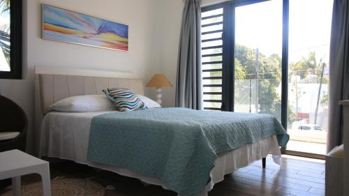 a bedroom with a bed and a large window at Villa Omoris 3 bedrooms Trou aux Biches, Sea Access in Trou aux Biches