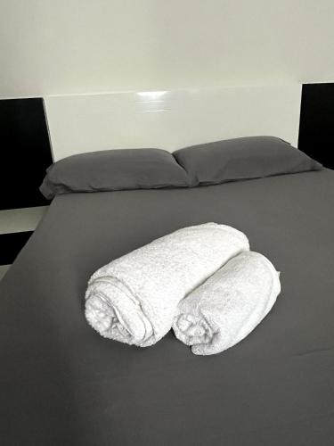 un letto con due asciugamani bianchi di GoBeyond - Serra T2 a Porto Novo