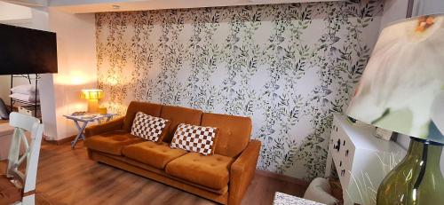 a living room with a brown couch and a curtain at Mary's House in Angra do Heroísmo