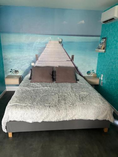 a bedroom with a bed with a painting of a pier at Le Lagon in Jargeau