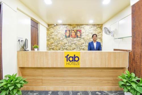 a man standing at the reception desk of a hotel at FabHotel Royal Empire - Bird Valley Udhyan in Chinchiwad