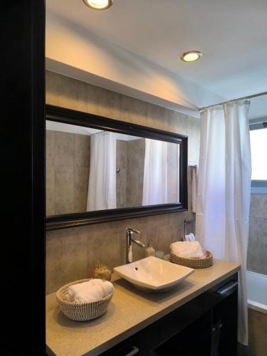 a bathroom with a sink and a large mirror at Blue Tulip - Strovolos in Kato Lakatamia