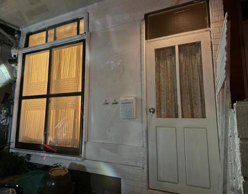 a front door of a house with a window at 経堂の小さな一棟貸wakusei in Tokyo