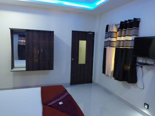 um quarto com uma televisão e uma porta num quarto em Konkan Paradise-Siddhivinayak,Devbag Beach Resort em Malvan