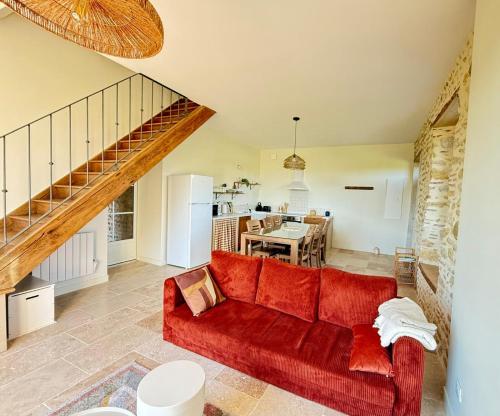 莫南Maison Ganibette, corps de ferme rénové的带红色沙发的客厅和厨房