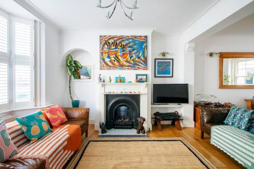 a living room with a couch and a fireplace at Heart of Brighton - Stylish - Victorian Terrace in Brighton & Hove