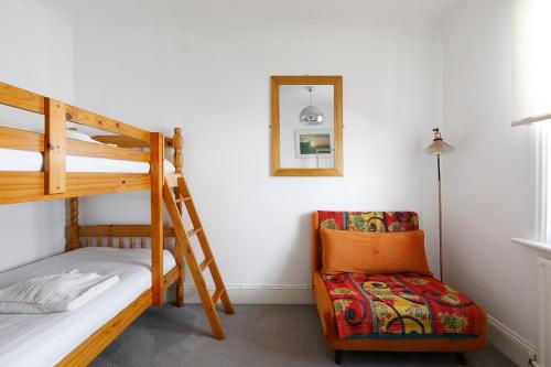 a bedroom with two bunk beds and a chair at Heart of Brighton - Stylish - Victorian Terrace in Brighton & Hove