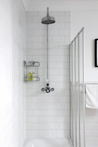 a white bathroom with a shower and a sink at Heart of Brighton - Stylish - Victorian Terrace in Brighton & Hove