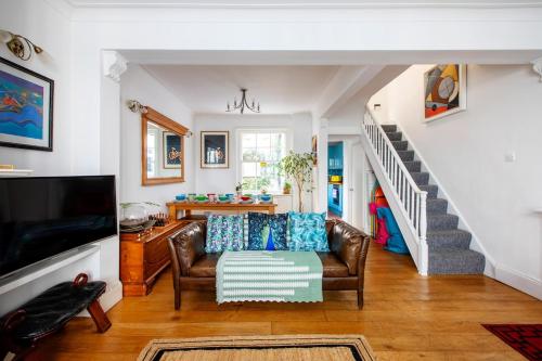 a living room with a couch and a staircase at Heart of Brighton - Stylish - Victorian Terrace in Brighton & Hove