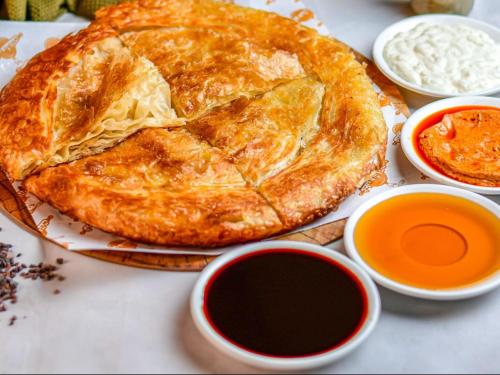 ファイユームにあるفيلا جاكرندا تونس Jacaranda Villa Tunisのテーブルの上に置かれたパイとディップソース