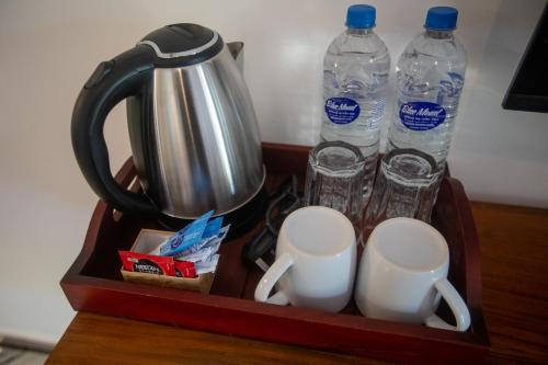 een dienblad met twee bekers en twee flessen water bij Middle of The Village Sigiriya in Palutawa