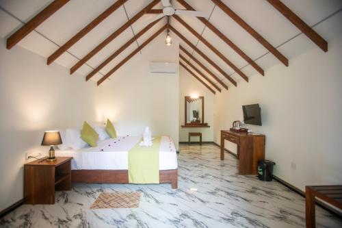 een slaapkamer met een bed en een tv in een kamer bij Middle of The Village Sigiriya in Palutawa