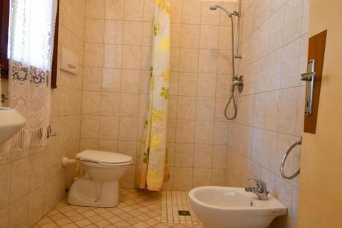 a bathroom with a toilet and a sink and a shower at Bright flat in Rosolina in Rosolina Mare