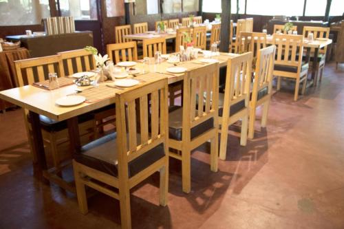 a long wooden table and chairs in a restaurant at Lotus an Eco Resort Konark in Konārka