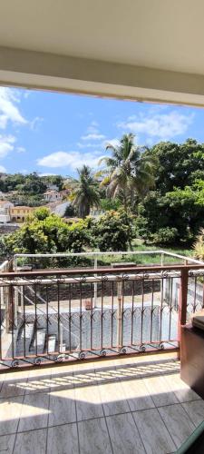 a balcony with a view of the ocean and palm trees at Casa LV 2 in Lençóis