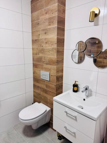 a bathroom with a white toilet and a sink at Perła Mórz 74 in Sianozety