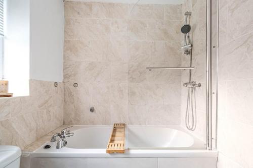 a white bath tub in a bathroom with a shower at Family & Contractors Retreat in Birmingham