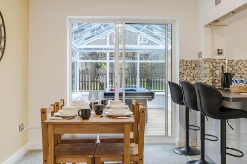 a dining room with a table and chairs and a window at Family & Contractors Retreat in Birmingham
