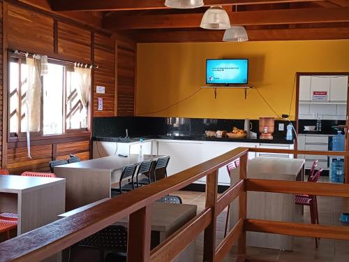 une salle à manger avec une télévision sur un mur dans l'établissement Pousada Da Nâna, à Palhoça