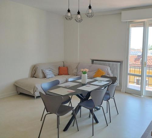 a living room with a table and chairs and a couch at Appartamento La Finestra sul Borgo in Santarcangelo di Romagna