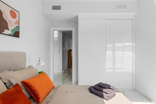 a white living room with a couch and orange pillows at Casa Azul in La Florida