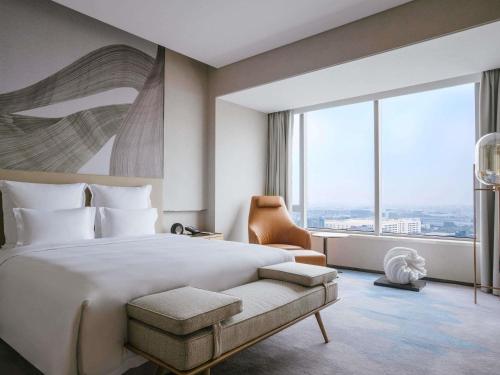 a bedroom with a large bed and a large window at Pullman Shanghai Qingpu Excellence in Shanghai