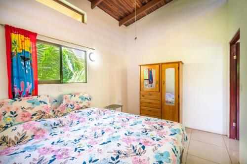 a bedroom with a bed and a window at Casa de las Palmas, Residencia Isabella in Parrita
