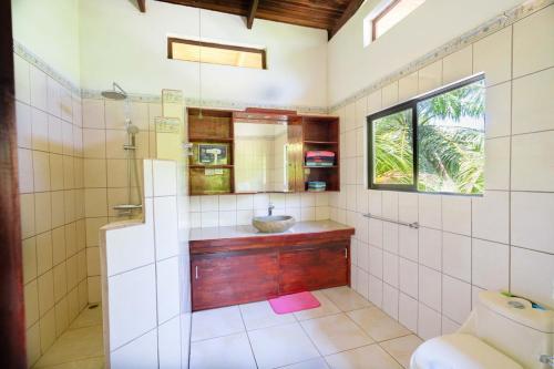 a bathroom with a sink and a shower at Casa de las Palmas, Residencia Isabella in Parrita