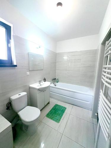 a bathroom with a toilet and a tub and a sink at Residence 2 in Ploieşti