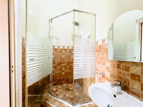 a bathroom with a shower and a sink at Golden Crystal Hotel in Accra