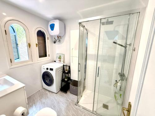 a bathroom with a shower and a washing machine at Miami Beach in Mogán
