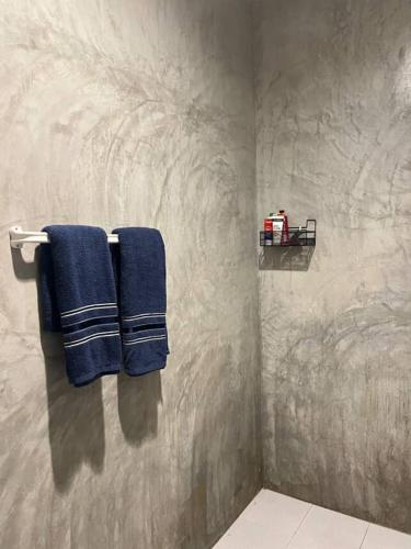 a bathroom with blue towels hanging on a wall at The Retreat Hotel Wellness & Spa in Krabi