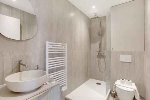 a bathroom with a tub and a toilet and a sink at Charmant et central - Neuilly in Neuilly-sur-Seine