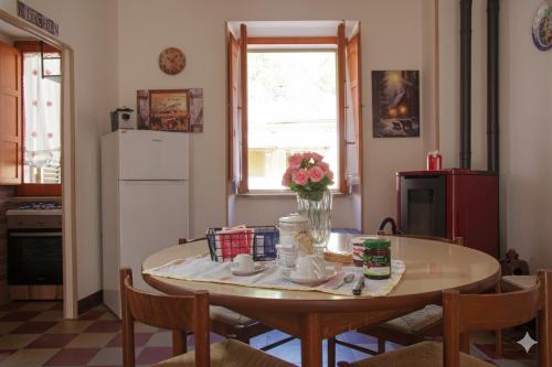 a kitchen with a table with a vase of flowers on it at "Il Quercione" Casa vacanze in Lama Di Peligni