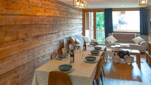 a dining room with a table and a couch at Cocon luxueux Le Cristal, pied de pistes, 10 couchages in Saint-Martin-de-Belleville