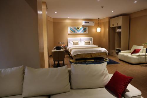 ein Hotelzimmer mit einem Bett und einer Couch in der Unterkunft Wealth Hotel Ikeja in Ikeja
