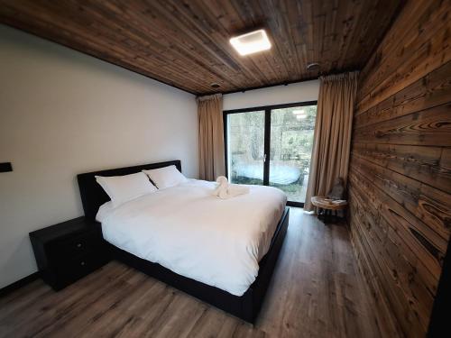 Un dormitorio con una cama y una ventana grande. en ZenArden, en Aywaille