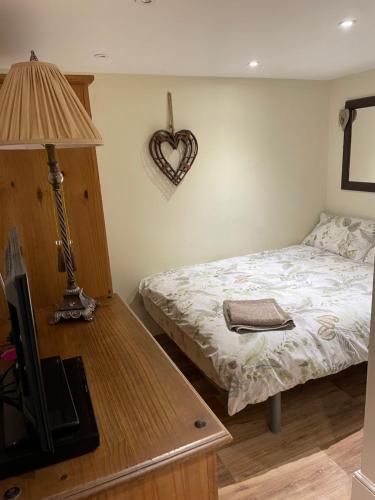 a bedroom with a bed with a heart on the wall at Deer Lodge in Thornton Curtis