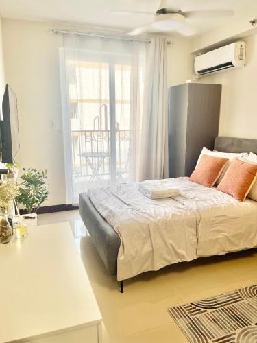 a bedroom with a bed and a balcony at Minimalist Studio-Type Condo Unit at Saekyung Marigondon in Suba